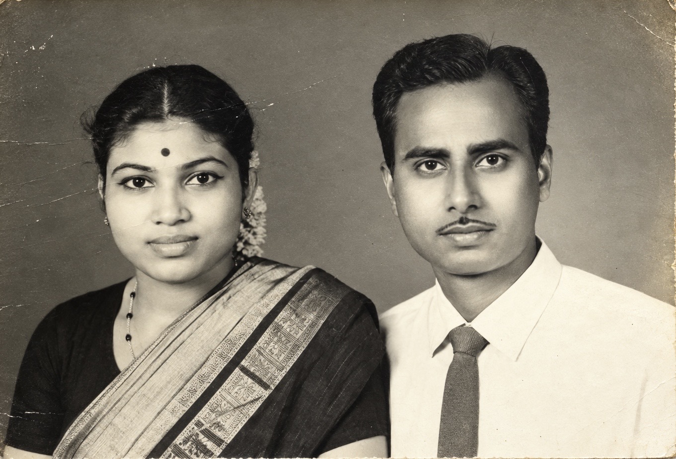 A black-and-white family portrait of a woman and a man seated together.